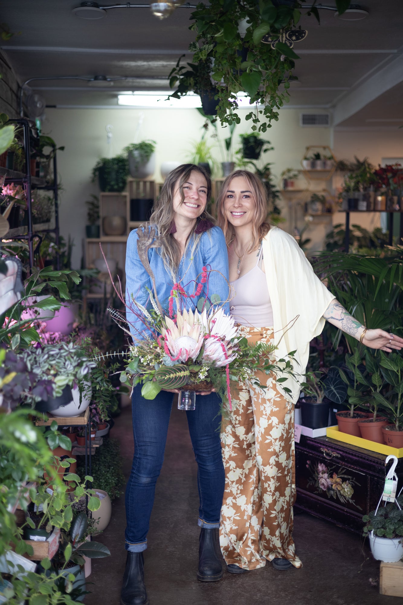 Sophie our florist & Meaghan the shop owner posing with one of their handmade bouquets.